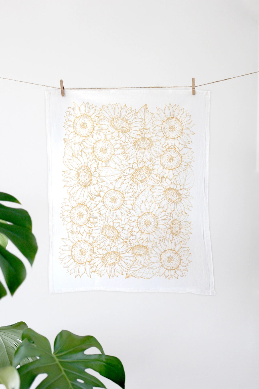 White tea towel with yellow sunflowers.