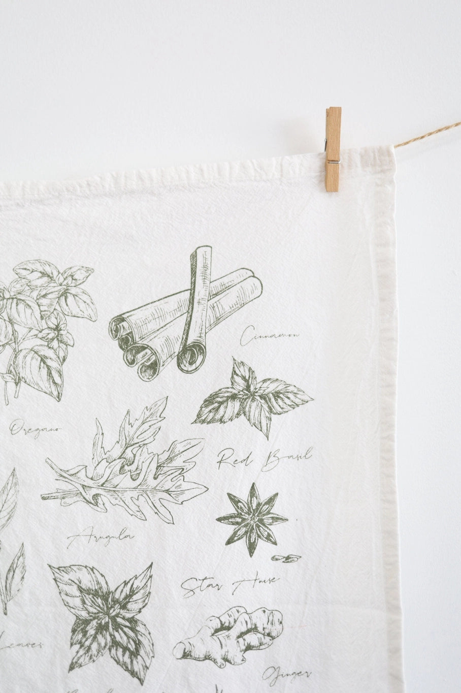 Close up of a tea towel that has spices and herbs on it.