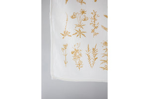 Close up of a white tea towel with yellow wild flowers