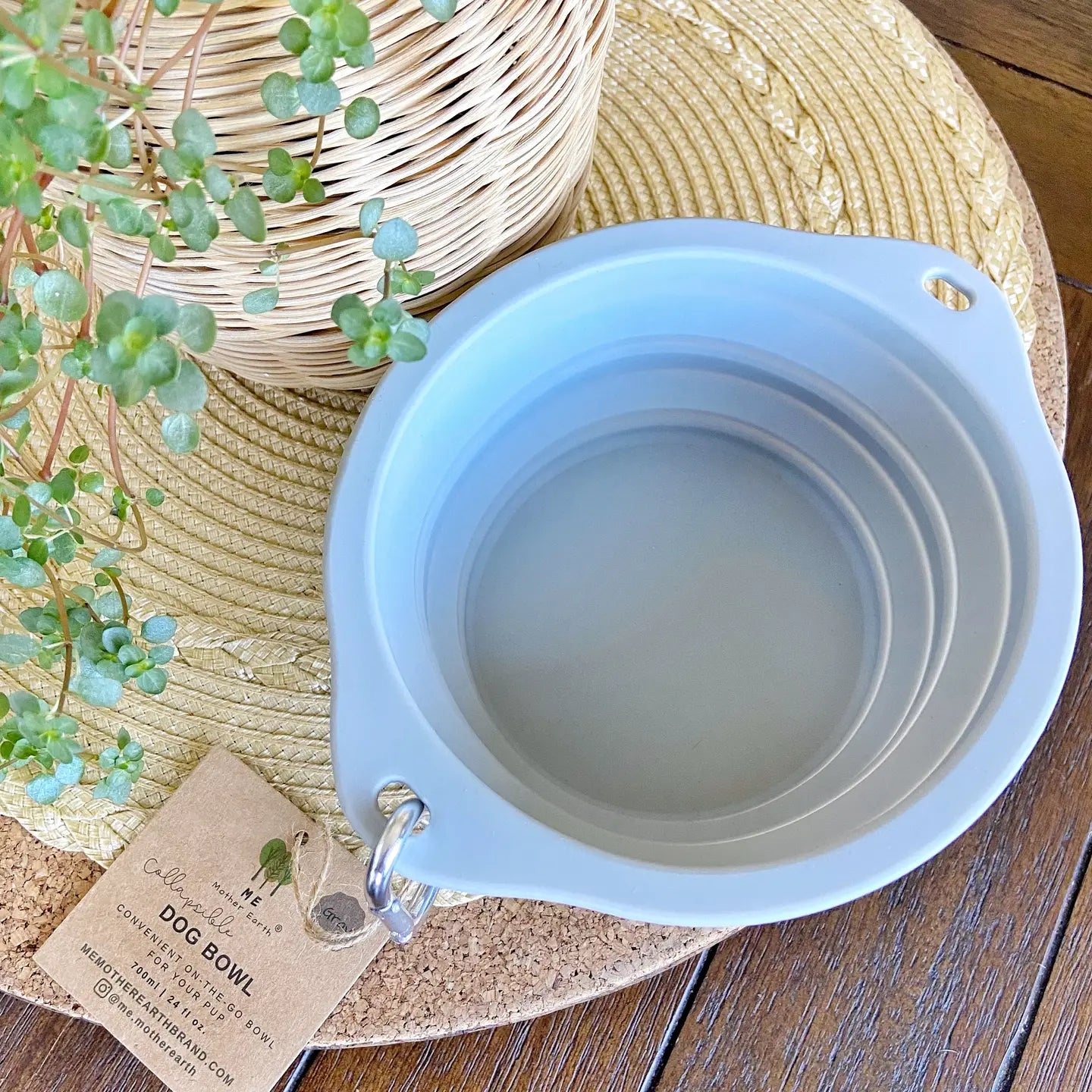 Gray silicone dog bowl on a wooden table.