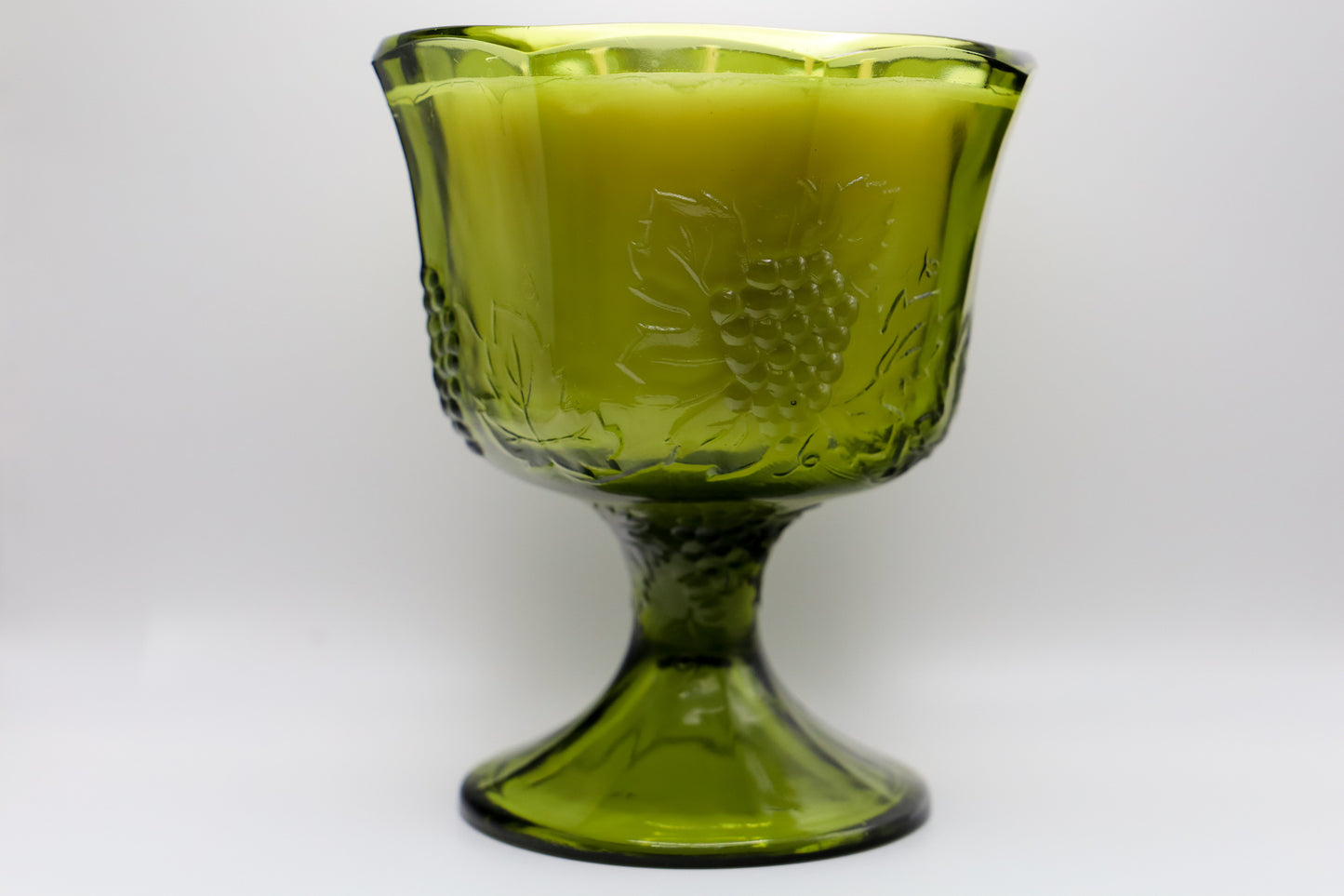 Large green glass compote in grape vine motif with white currant scented 3 wick soy candle