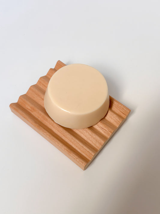 White conditioner bar on a wooden dish