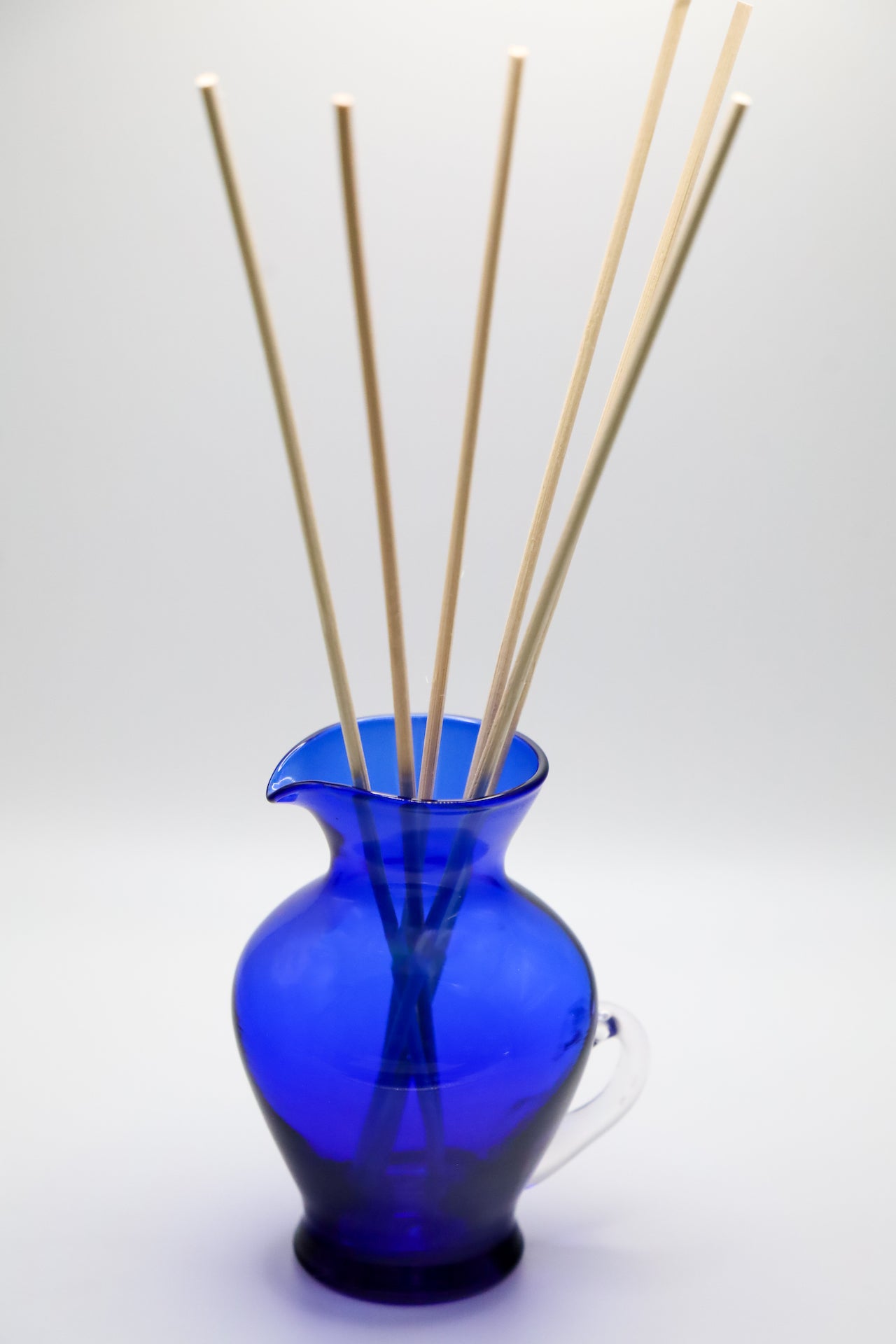 Blue glass mini pitcher as diffuser container