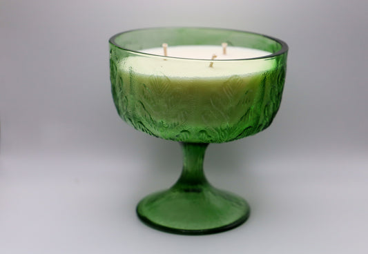 Green glass container with oak leaf pattern filled with cedarwood blanc scented candle