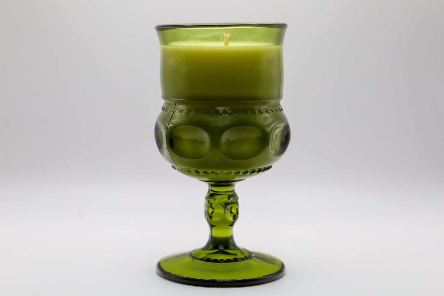 Color Crown Green Water Goblet with Cedar and Amber scented soy candle.