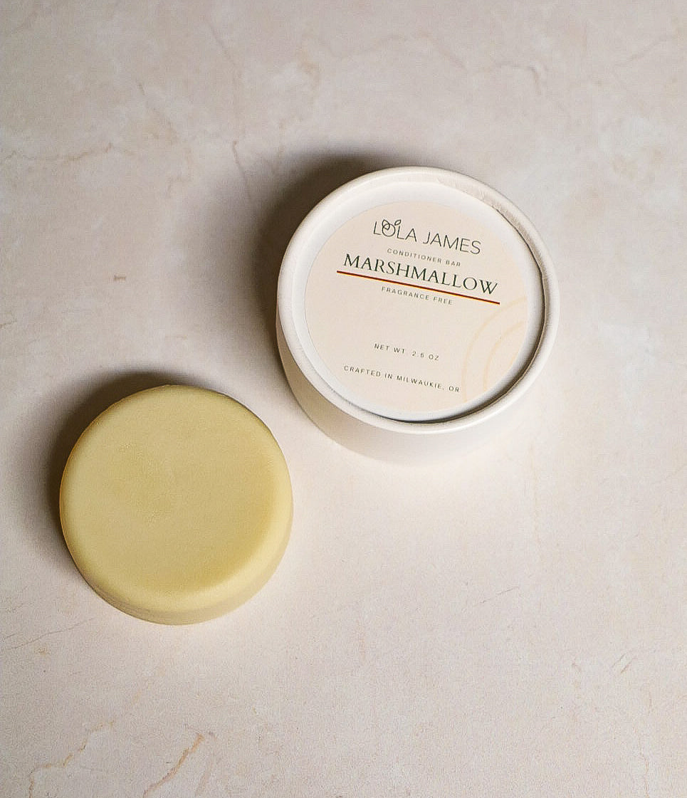 Cream conditioner bar sitting next to packaging.