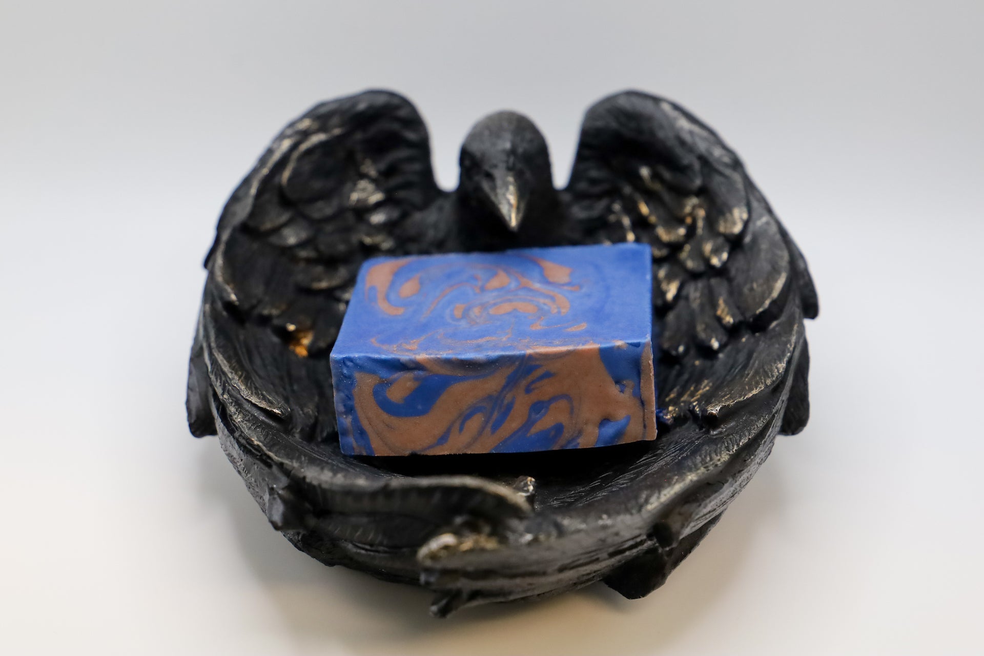 Deep blue colored soap with bronze swirls, complex scent blending woods and citrus.