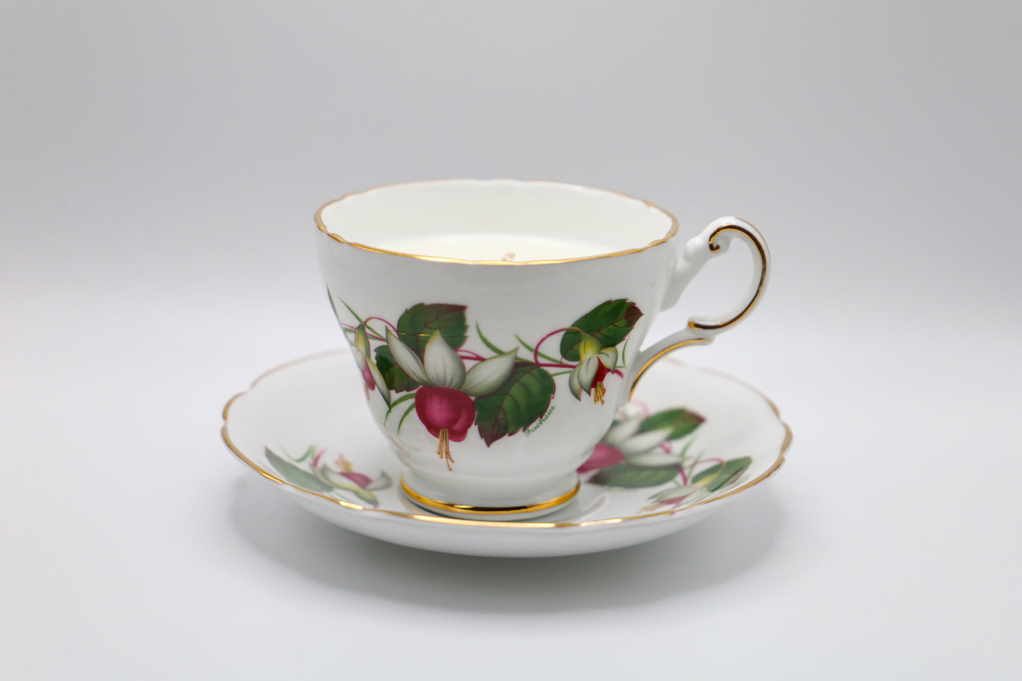English Bone China Tea cup and saucer with fuchsia motif, filled with lush succulent scented soy candle.