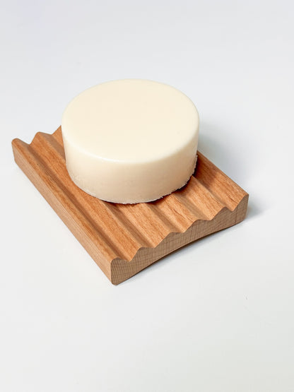 White body butter bar on a wooden tray.