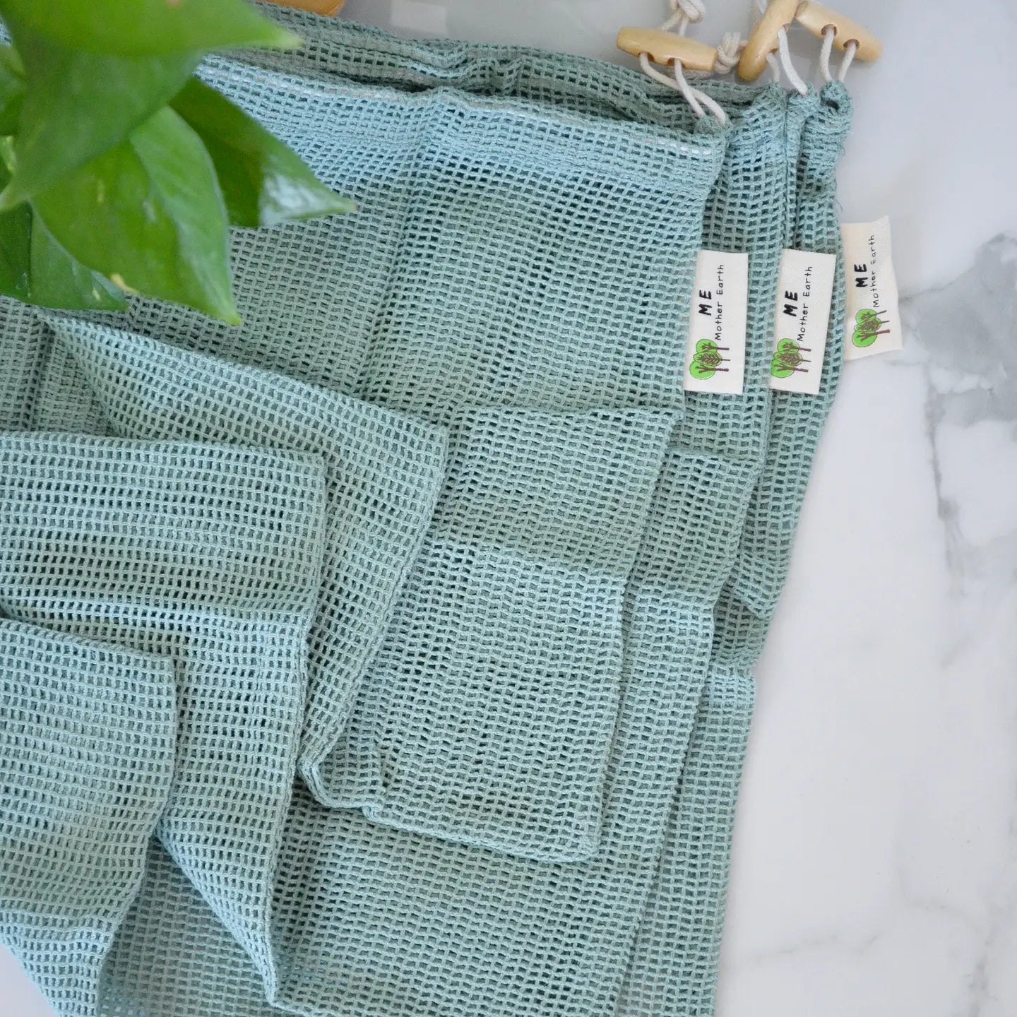 Stack of 3 sage green cotton product bags.